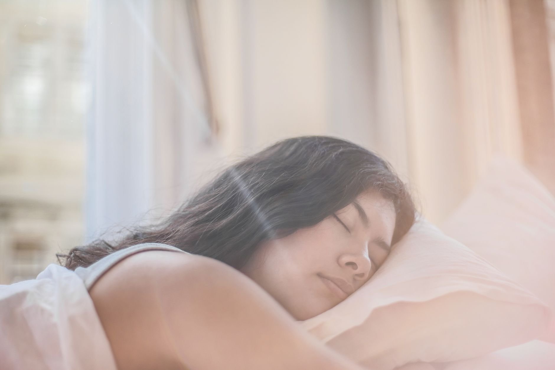 Woman sleeping peacefully in soft morning light — the outcome we want for every reader